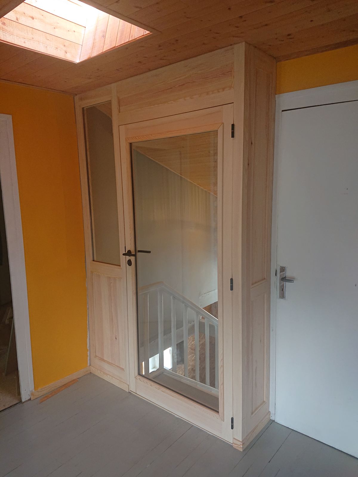 Cloison et porte vitrée en pin sylvestre, en haut d'un escalier