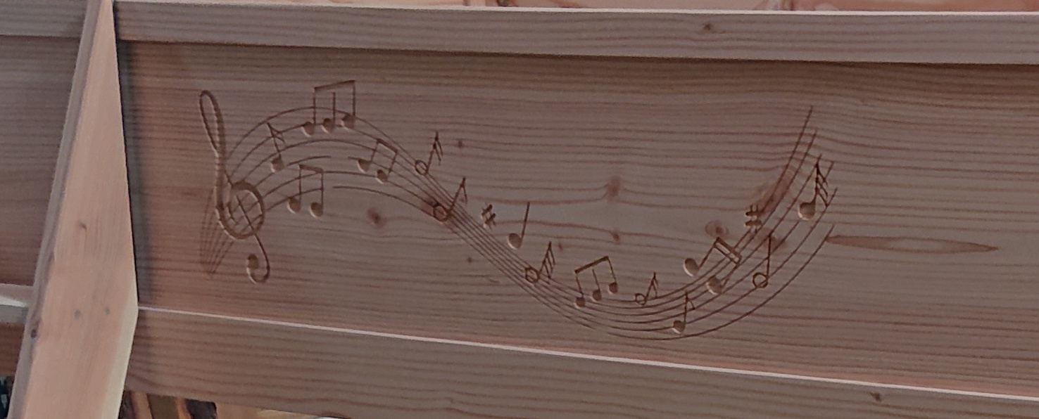 Gravure CNC représentant une portée musicale sur une pièce de bois massif