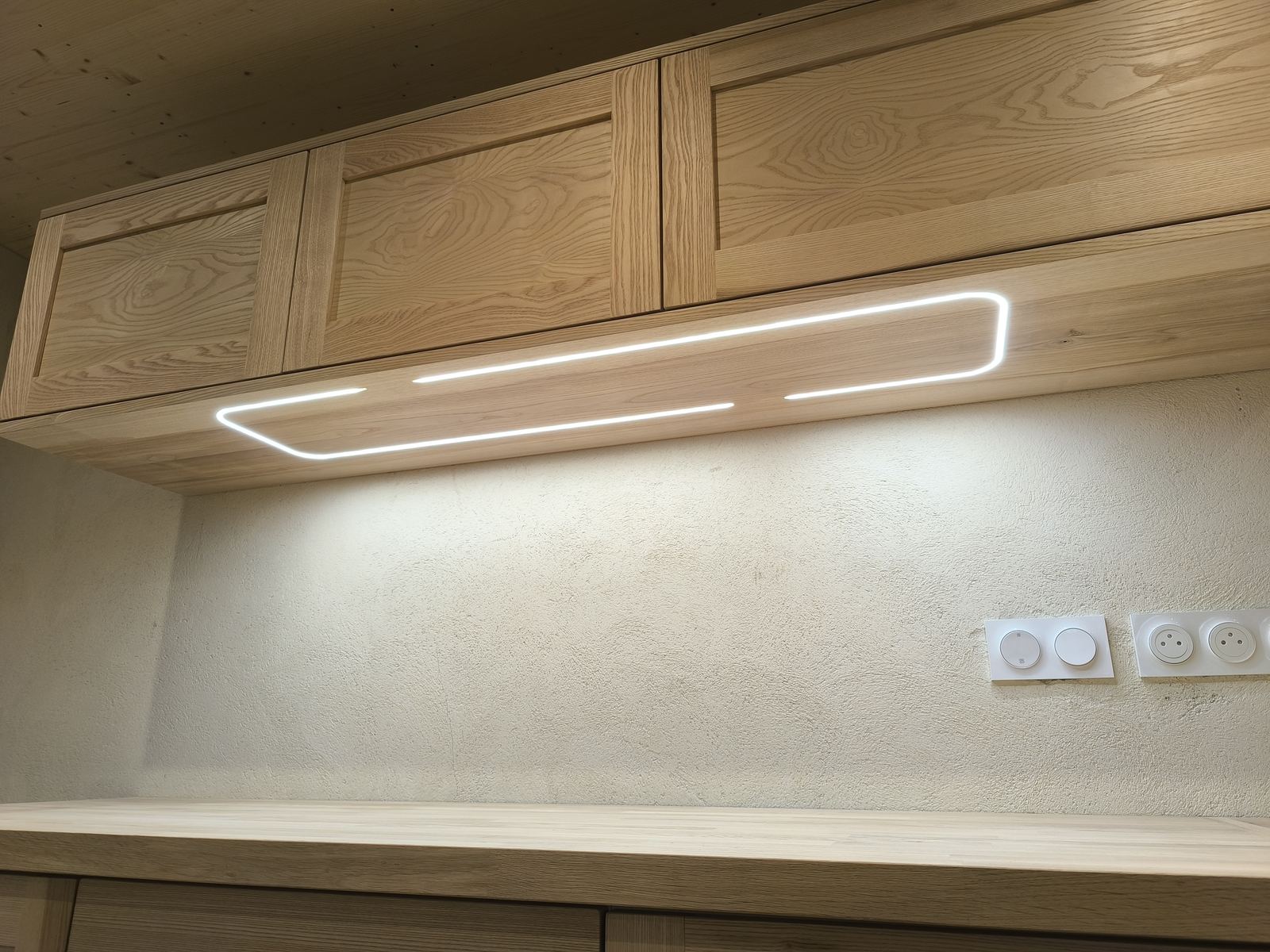 Meuble haut de cuisine en frêne avec un bandeau lumineux LED intégré et fraisé à la CNC